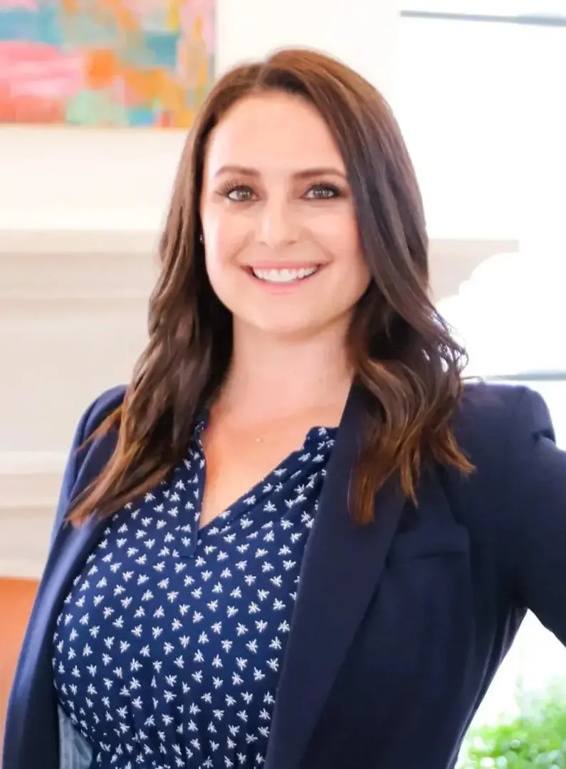 A woman in a blue polka dot shirt and jacket.