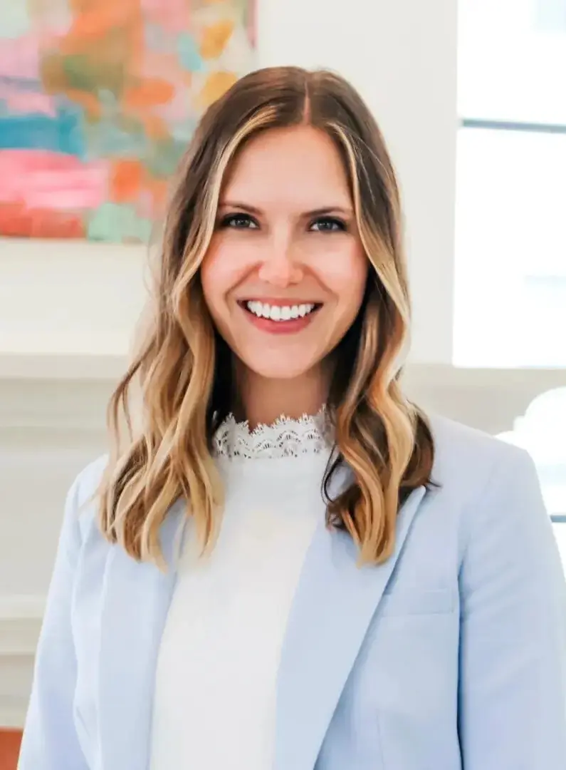 A woman in a blue suit smiling for the camera.